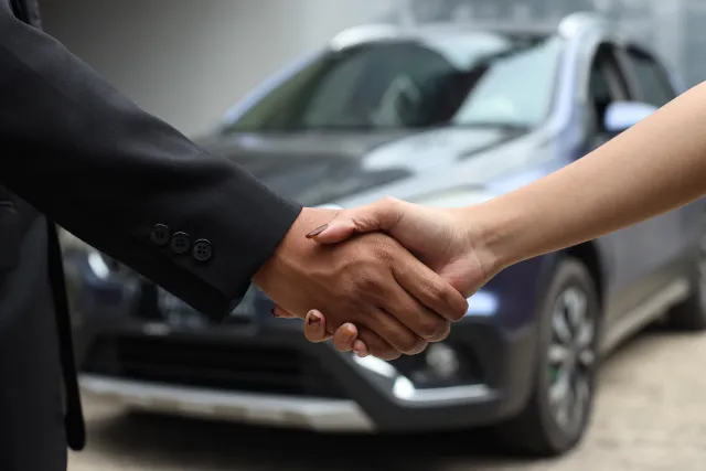 cropped-closeup-image-salesman-shaking-hands-with-his-client-after-selling-car-dealers